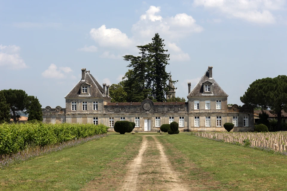 Château viticole avec façade en pierre calcaire, toitures à la Mansart et cheminées multiples