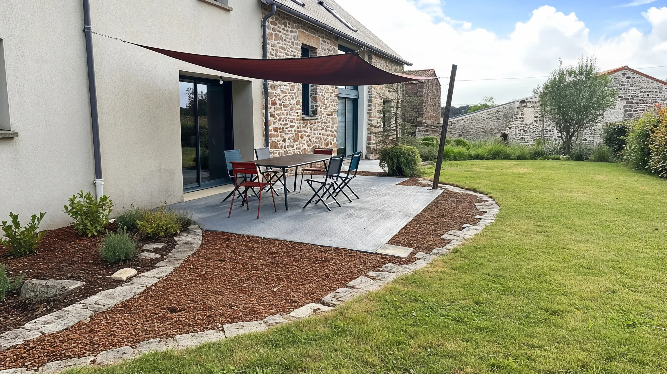 Escalier ext&eacute;rieur en pierre naturelle avec murets de sout&egrave;nement, int&eacute;gr&eacute; dans un jardin paysager avec plantations vivaces color&eacute;es et arbustes d&eacute;coratifs