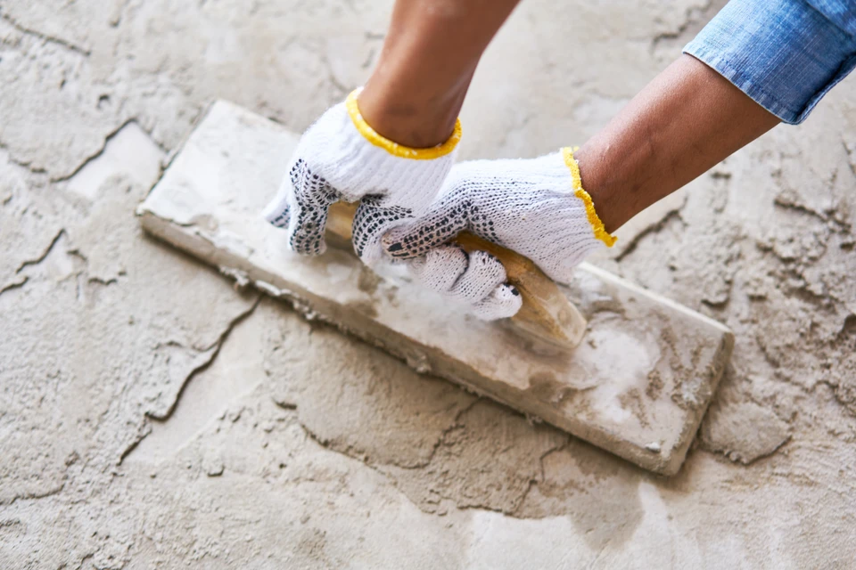 Deux hommes serrant la main dans une maison à moitié construite en bois avec un plan de construction à côté d'eux pour exprimer leur satisfaction à l'égard du progrès