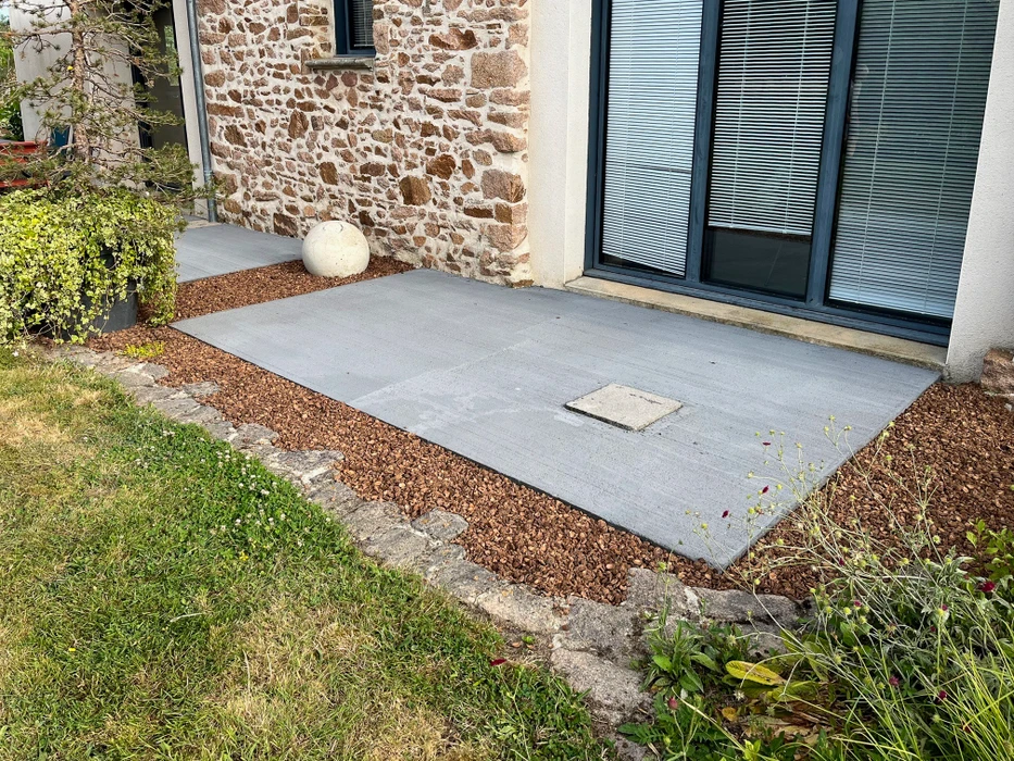 Terrasse extérieure moderne avec salon de jardin comprenant table rectangulaire et chaises pliantes multicolores (rouge, bleue, noire)