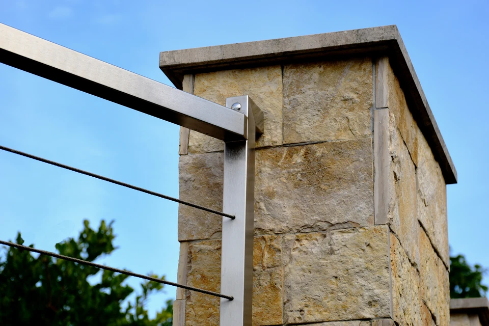 Maison contemporaine avec façade en pierre naturelle empilée et volumes blancs géométriques